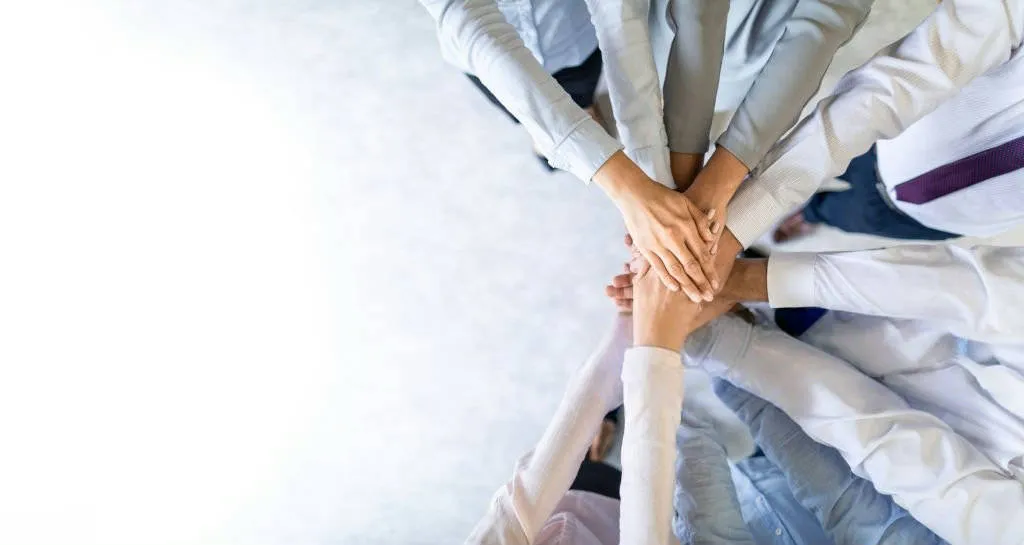 Close up top view of young business people putting their hands together. Stack of hands. Unity and teamwork concept.